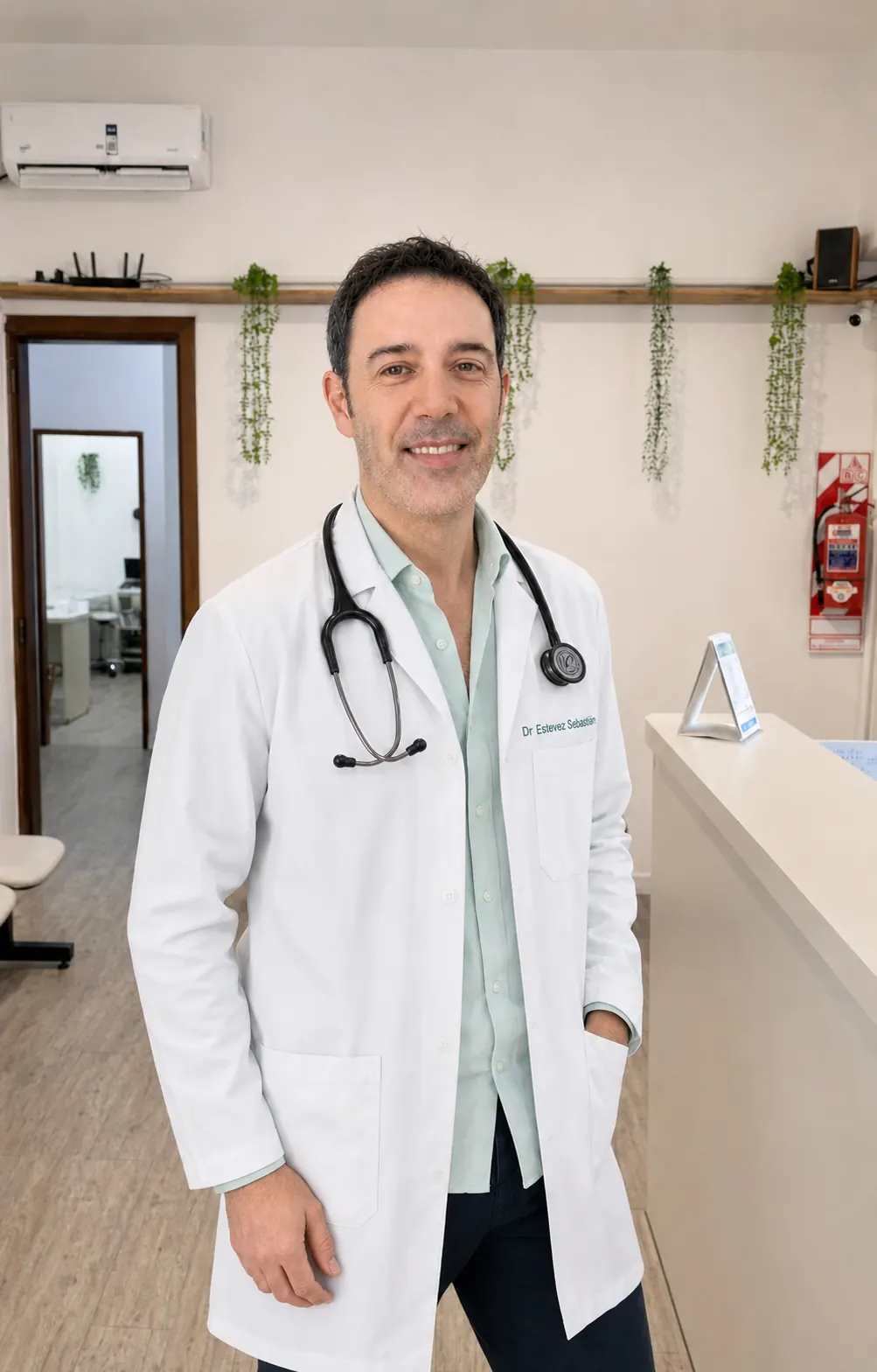 Dr. Sebastián Estévez con guardapolvo y estetoscopio en su consultorio